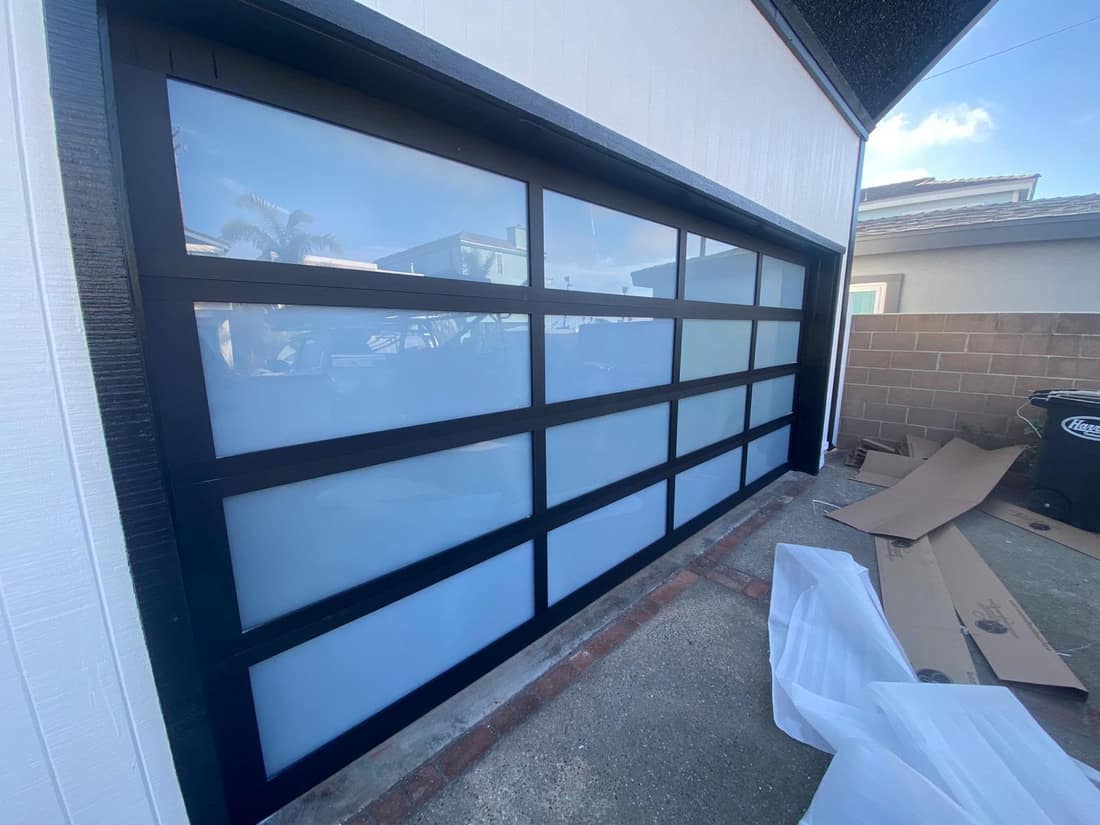 Modern black full-view glass garage door installed in Orange County